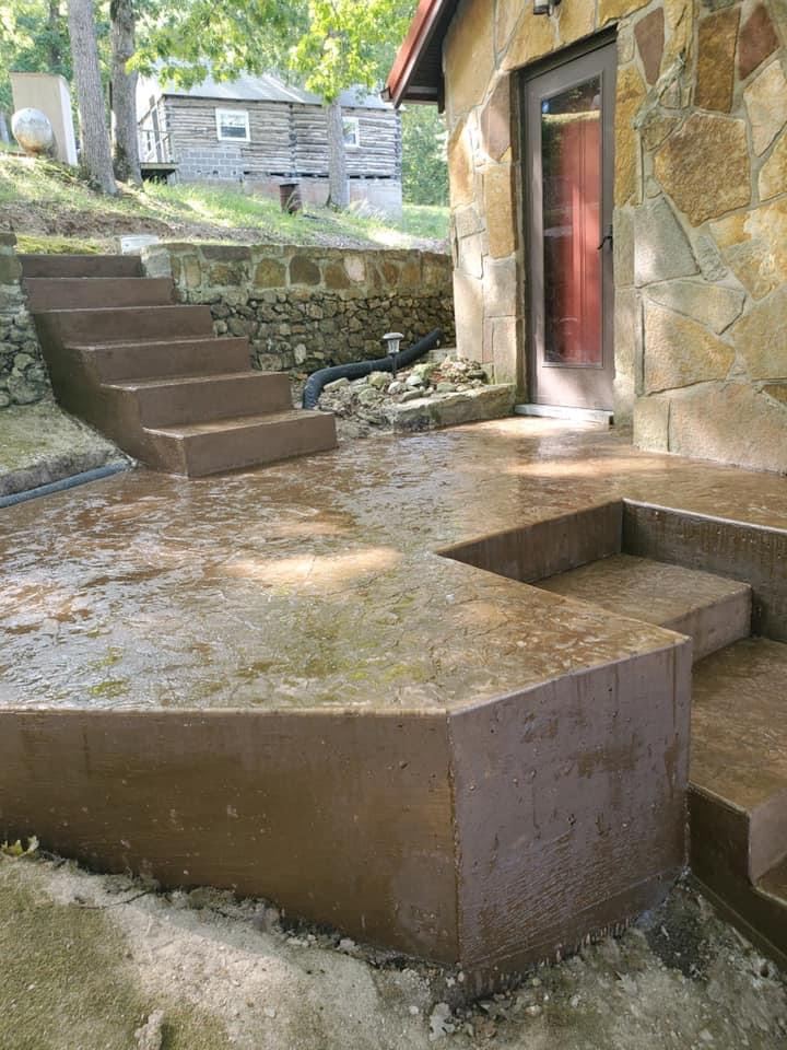 Brown stamped concrete patio and steps at a stone cottage